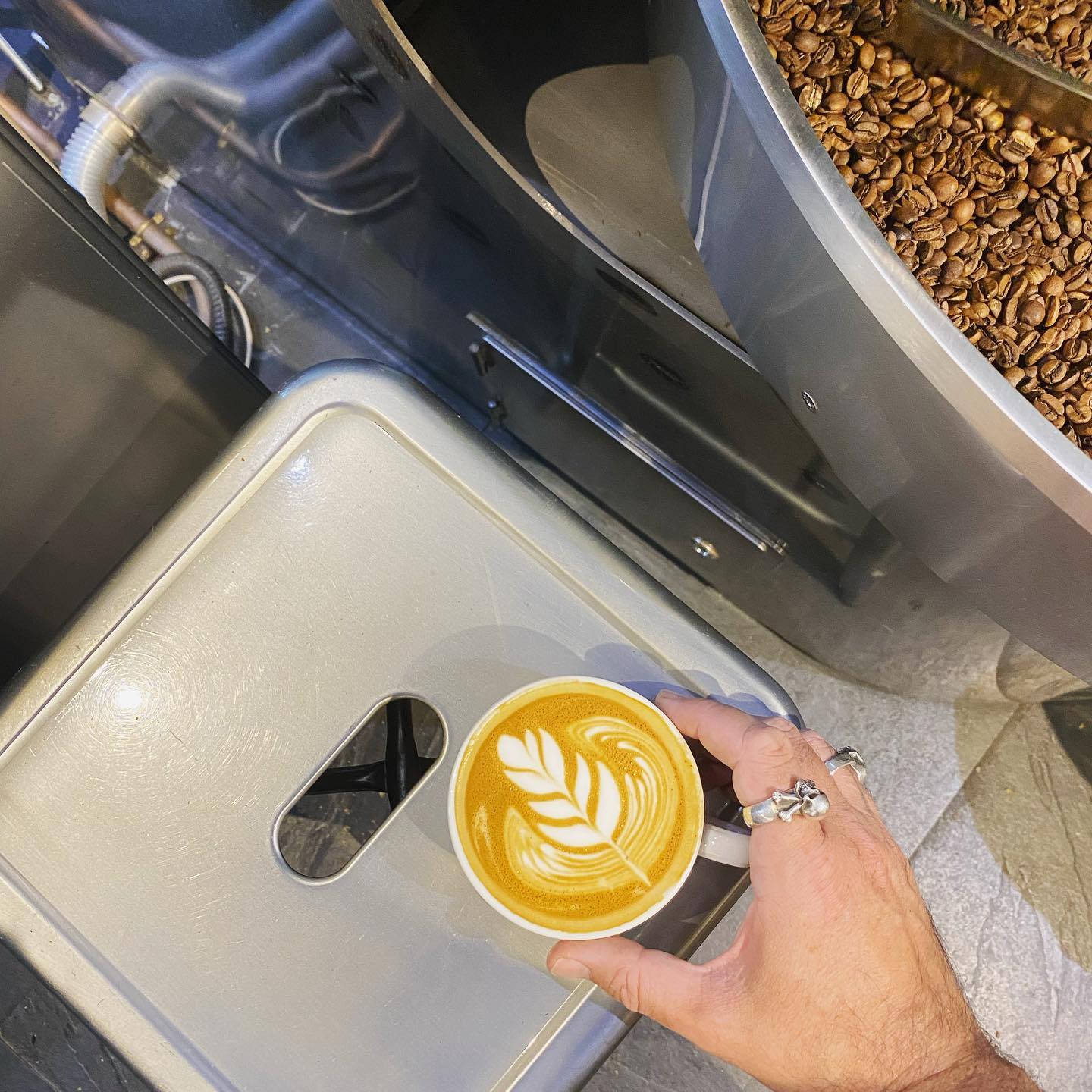 Rising Ground Cortado beside coffee roaster
