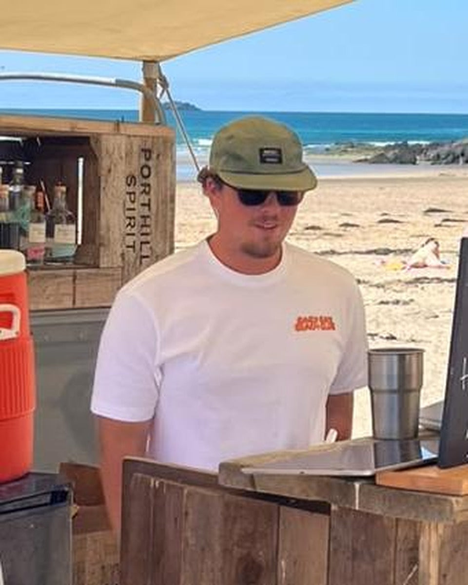 Baby Bay Beach Club white t-shirt, front logo, behind the beach bar